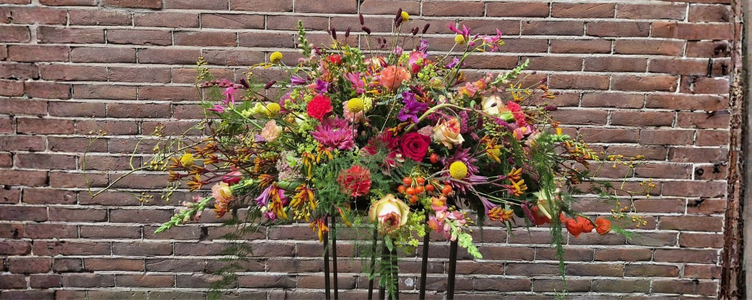 Rouwbloemwerk tegen een bakstenen muur